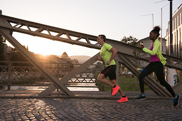 Image showing young multiethnic couple jogging in the city