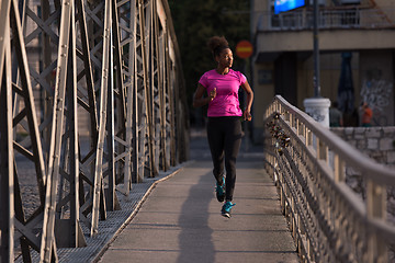 Image showing african american woman running across the bridge