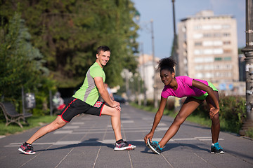 Image showing jogging couple warming up and stretching in the city