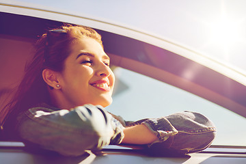 Image showing happy teenage girl or young woman in car