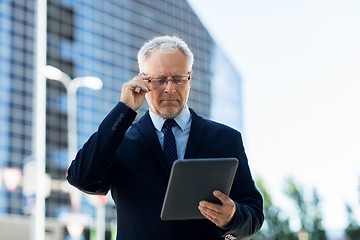 Image showing senior businessman with tablet pc on city street