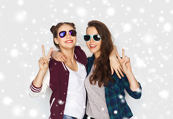 Image showing smiling teenage girls in sunglasses showing peace