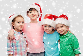 Image showing happy little children in santa hats hugging