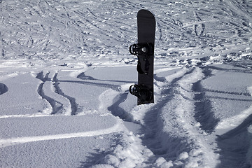 Image showing Snowboard in snowdrift and off-piste slope