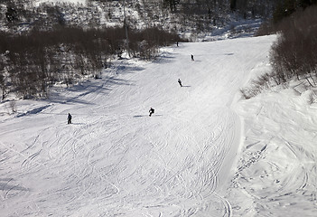 Image showing Snowboarders and skiers on ski slope at winter day