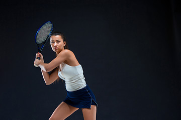 Image showing Portrait of beautiful girl tennis player with a racket on dark background