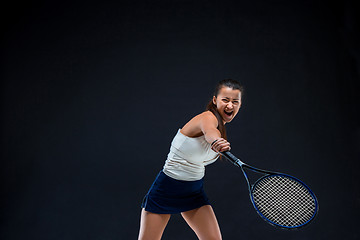 Image showing Portrait of beautiful girl tennis player with a racket on dark background