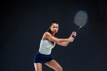 Image showing Portrait of beautiful girl tennis player with a racket on dark background