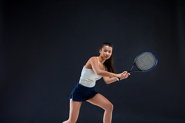 Image showing Portrait of beautiful girl tennis player with a racket on dark background