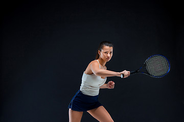 Image showing Portrait of beautiful girl tennis player with a racket on dark background