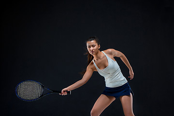 Image showing Portrait of beautiful girl tennis player with a racket on dark background