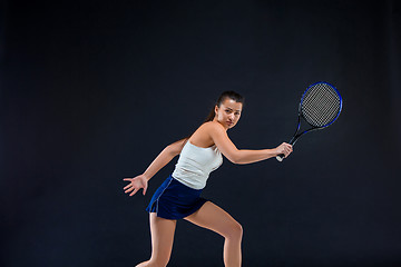 Image showing Portrait of beautiful girl tennis player with a racket on dark background