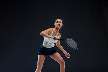 Image showing Portrait of beautiful girl tennis player with a racket on dark background