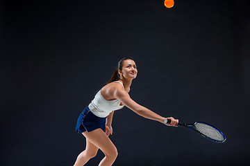 Image showing Portrait of beautiful girl tennis player with a racket on dark background