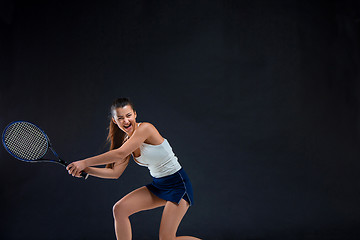 Image showing Portrait of beautiful girl tennis player with a racket on dark background