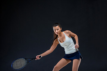 Image showing Portrait of beautiful girl tennis player with a racket on dark background