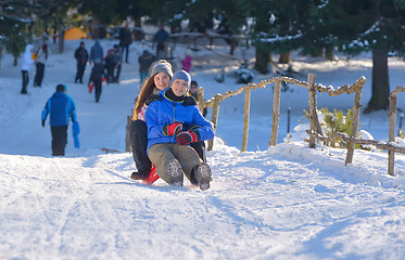 Image showing teenagers slide downhill 