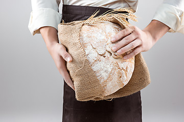 Image showing Baker man holding rustic organic loaf of bread in hands