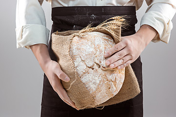 Image showing Baker man holding rustic organic loaf of bread in hands