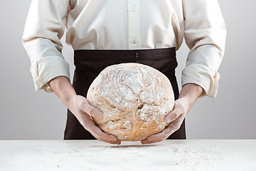 Image showing Baker man holding rustic organic loaf of bread in hands