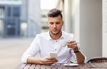 Image showing man with smartphone drinking coffee at city cafe