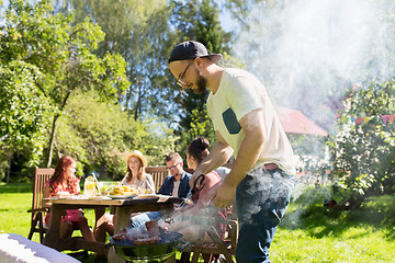 Image showing man cooking meat on barbecue grill at summer party