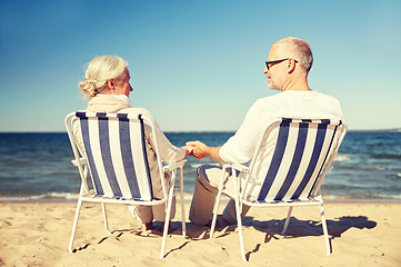 Image showing happy senior couple in chairs on summer beach