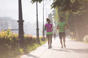 Image showing young multiethnic couple jogging in the city