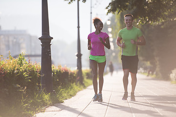 Image showing young multiethnic couple jogging in the city