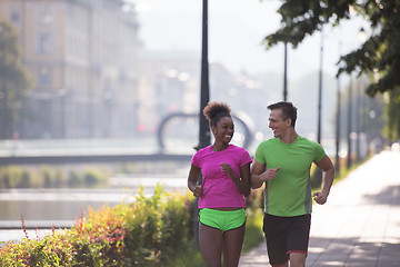 Image showing young multiethnic couple jogging in the city