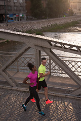 Image showing young multiethnic couple jogging in the city