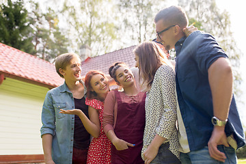 Image showing happy teenage friends talking at summer garden