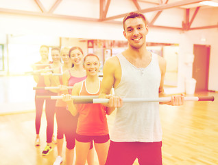 Image showing group of smiling people working out with barbells