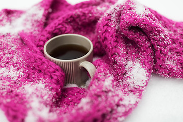 Image showing close up of tea or coffee and winter scarf in snow