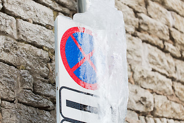 Image showing ice-covered no stopping road sign over wall