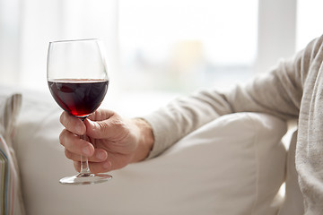 Image showing close up of hand holding glass with red wine