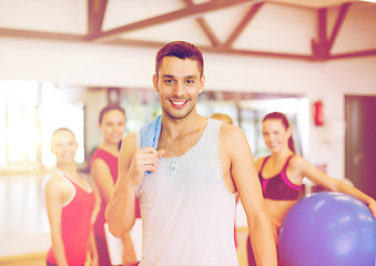 Image showing smiling man standing in front of the group in gym