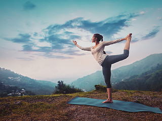Image showing Woman doing yoga asana Natarajasana outdoors on sunset