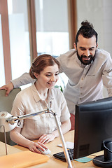 Image showing happy creative team with computer in office