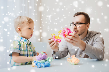 Image showing father and son playing with ball clay at home