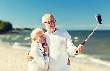 Image showing happy senior couple hugging on summer beach