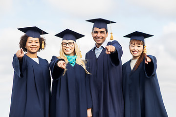 Image showing happy students or bachelors pointing finger at you