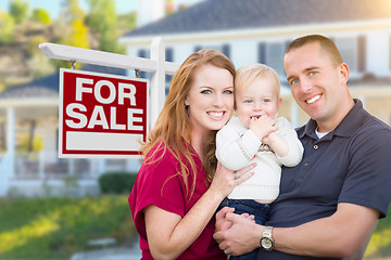 Image showing Young Military Family in Front of For Sale Sign and House