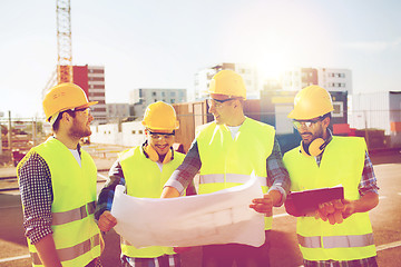 Image showing group of builders with tablet pc and blueprint