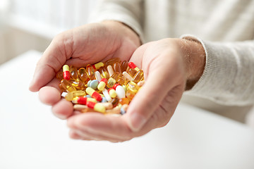 Image showing close up of old man hands holding medicine