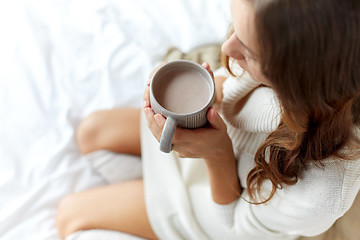 Image showing close up of woman with cocoa cup in bed at home