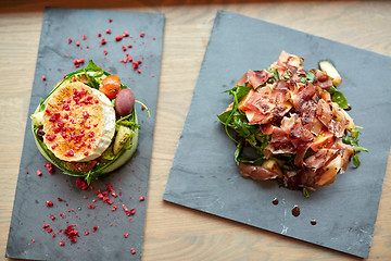 Image showing goat cheese and ham salads on stone plates