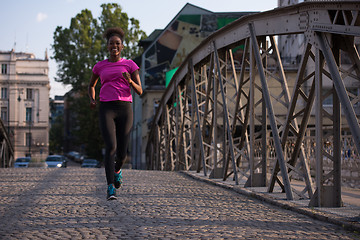 Image showing african american woman running across the bridge