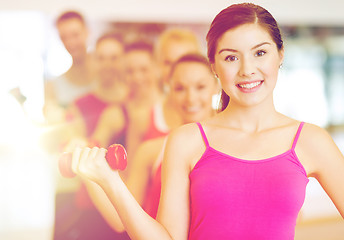 Image showing group of smiling people with dumbbells in the gym