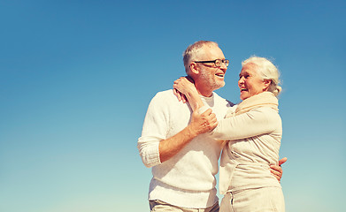 Image showing happy senior couple hugging outdoors